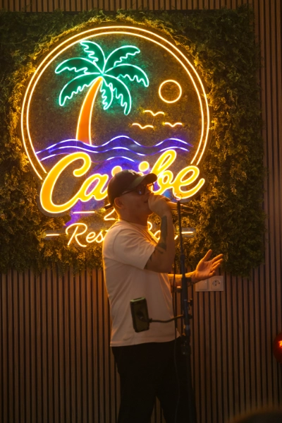 Artista cantando junto al letrero de Caribe 2.0